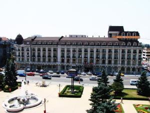 a large building with a large clock on the side of it at Hotel Central in Ploieşti