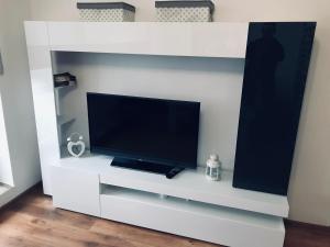 a white entertainment center with a flat screen tv at Apartament Silesia Park in Katowice