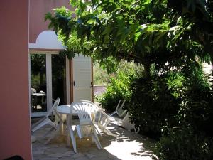a patio with a table and chairs and a tree at Villa avec piscine in Cap d'Agde