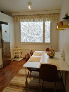 a kitchen and dining room with a table and a window at Sun Apart Vuorenrinne in Kotka
