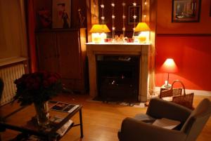 a living room with a fireplace and a chair at Chez Jeanne et Vittorio in Lambersart