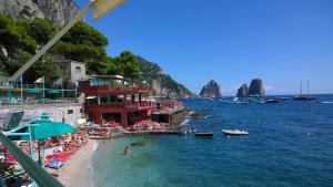 a beach with a group of people and boats in the water at La Casetta di Anna in Capri