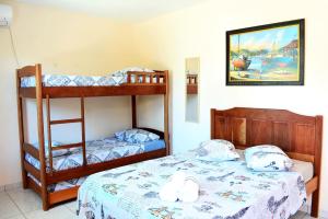 a bedroom with two bunk beds and a bed at Hotel e Pousada Boulevard de Itapoa in Itapoa