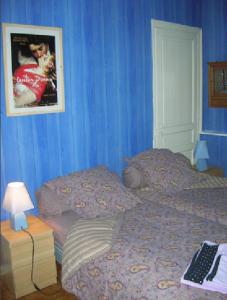 a bedroom with blue walls and a bed with a keyboard at Chez Jeanne et Vittorio in Lambersart