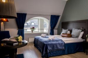 
a bedroom with a bed, chair, table and window at Frogner House Apartments - Skovveien 8 in Oslo
