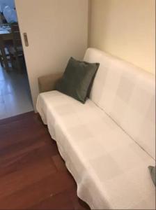 - un canapé blanc avec un oreiller vert dans l'établissement Amazing flat in Madragoa, à Lisbonne