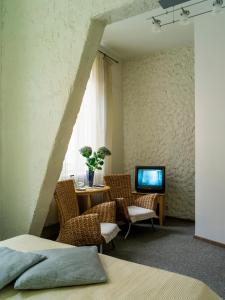 una camera con tavolo, sedie e televisore di Elizabete Design Hotel a Riga