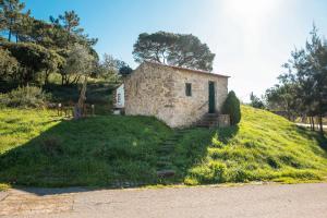 an old stone house on a grassy hill at Casa Rústica, perto do Castelo de Óbidos in Óbidos