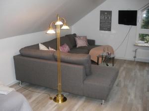 a living room with a couch and a floor lamp at Ferienwohnung am Jordan in Schneverdingen