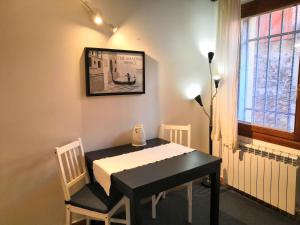 einen schwarzen Tisch und Stühle in einem Zimmer mit Fenster in der Unterkunft CASTELLO Ground Floor in Venedig