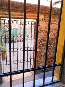 einen Blick durch ein vergittertes Fenster auf einen Innenhof in der Unterkunft CASTELLO Ground Floor in Venedig