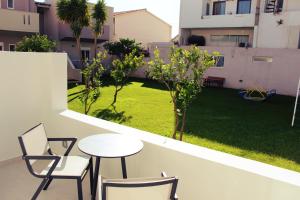 a balcony with a table and chairs and a lawn at Luxury Apartments Near to the beach in Plakias