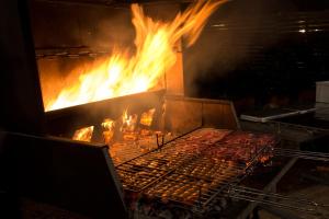 a grill with a bunch of fire in it at Hotel Garden Salento in Torre Vado