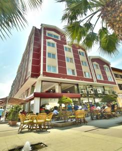 a large building with tables and chairs in front of it at Grand Akçalı Otel in İskenderun