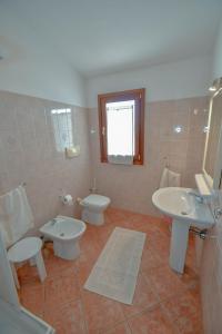 a bathroom with two sinks and two toilets at Agriturismo Sardo in Campavaglio