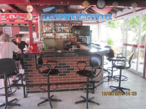 een bar met zwarte stoelen voor een bakstenen muur bij Red Rose Hotel in Oludeniz