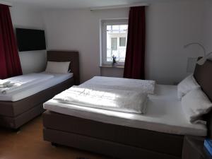 zwei Einzelbetten in einem Zimmer mit Fenster in der Unterkunft Tuniberg Restaurant Hotel in Freiburg im Breisgau