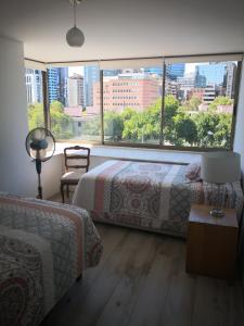 a bedroom with two beds and a large window at Lindo departamento a pasos del Centro comercial Costanera Center in Santiago
