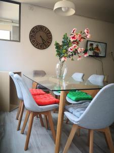 a dining room table with chairs and a vase with flowers at Lindo departamento a pasos del Centro comercial Costanera Center in Santiago