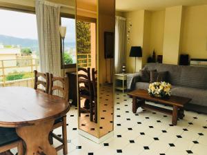 salon ze stołem i kanapą w obiekcie Precioso apartamento en S'Agaró con fantásticas vistas al mar w Sant Feliu de Guixols