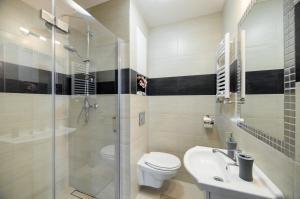 a bathroom with a toilet and a sink and a shower at Apartamenty Wieniawa in Lublin +8 photos