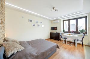 a bedroom with a bed and a dining room with a table at Apartamenty Wieniawa in Lublin