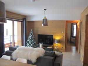 a living room with a christmas tree and a couch at Le Bianca 102 Residence l'Epinette in Valloire
