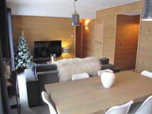 a living room with a table and a couch with a white fur at Le Bianca 102 Residence l'Epinette in Valloire