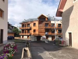 Casa de madera grande con balcón en un edificio en Le Bianca 102 Residence l'Epinette, en Valloire