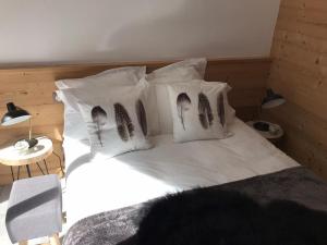 a bed with white sheets and pillows with her feet on it at Le Bianca 102 Residence l'Epinette in Valloire