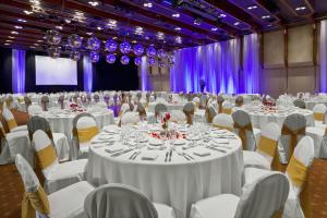 um grande salão de banquetes com mesas e cadeiras brancas em Libertador Hotel em Buenos Aires