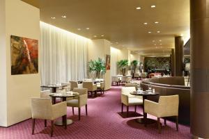 a restaurant with tables and chairs and a bar at Libertador Hotel in Buenos Aires