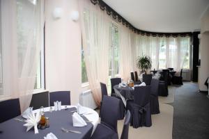 uma sala de jantar com mesas, cadeiras e janelas em Family Hotel Diana em Sófia