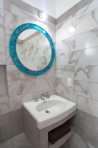 ein Badezimmer mit einem Waschbecken und einem blauen Spiegel in der Unterkunft Villa Alebrije Cozumel in Cozumel