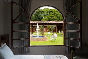 a bedroom with a view of a fountain through a window at Hostel SLG in Maringá