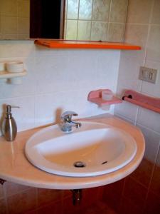 a white sink in a bathroom with a mirror at Sardinia Yellow House in Solanas