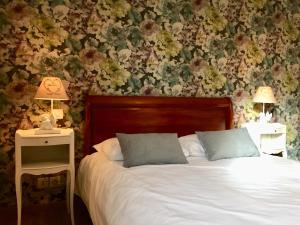 a bedroom with a bed and two night stands with lamps at Chambre d'hôtes in La Membrolle-sur-Choisille