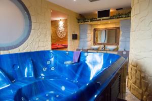Una gran bañera azul en el baño con lavabo en Motel Venus Valladolid, en Villanubla