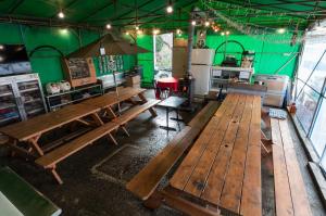 a restaurant with wooden tables and a green wall at Suanbo Saipan Hot Spring Hotel in Chungju