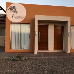 ein Gebäude mit zwei Türen und einem Schild darauf in der Unterkunft Apart Las Palmeras Corcovado in Villa Rumipal