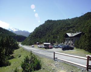 a road with cars parked on the side of a mountain at Chalet Villa Valania in Valdidentro