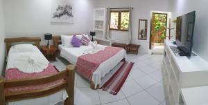 a bedroom with two beds and a computer in it at Pousada Caminho da Praia in Jericoacoara