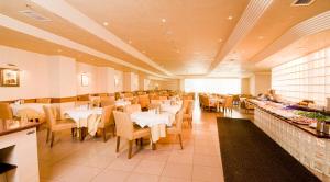 un comedor con mesas y sillas blancas en un restaurante en Hotel Buyuk Keban, en Estambul