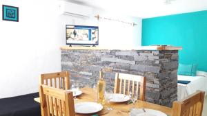 a dining room with a table and chairs and a stone fireplace at Cabañas Aramaití in San Rafael