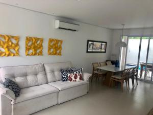 ein Wohnzimmer mit einem weißen Sofa und einem Tisch in der Unterkunft Casa de temporada in Juquei