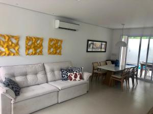 a living room with a white couch and a table at Condomínio casa Juquehy in Juquei