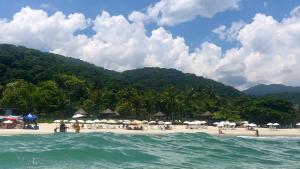a beach with umbrellas and people on the beach at Condomínio casa Juquehy in Juquei