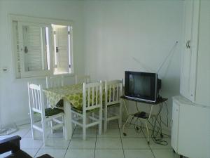 a dining room with a table and a television at Aluguel de Verão in Torres