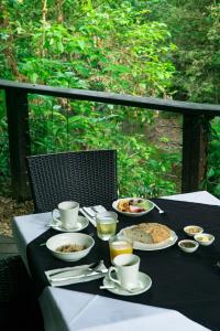 a table with plates of food and drinks on it at Heritage Lodge in Daintree