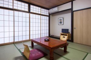 a room with a table, chairs, and a window at Nikko Tokanso in Nikko